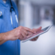 Mid section of male surgeon using digital tablet in operation room at hospital